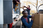 personnes qui mettent des cartons dans un camion de déménagement